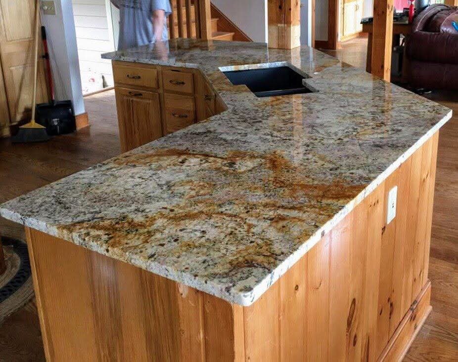 Gold-veined granite peninsula over knotty pine cabinets