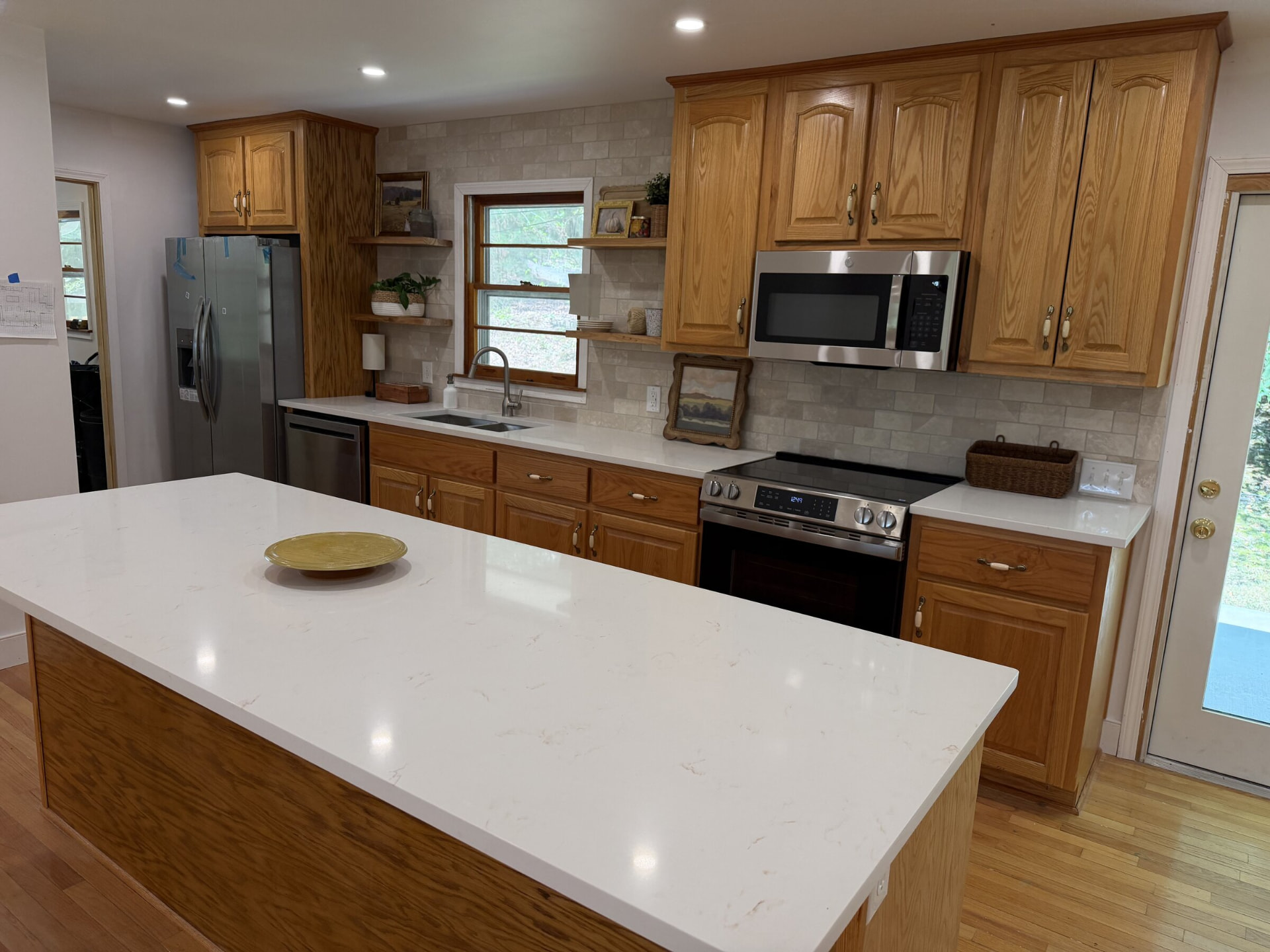 Large white quartz island in a kitchen with oak cabinetry