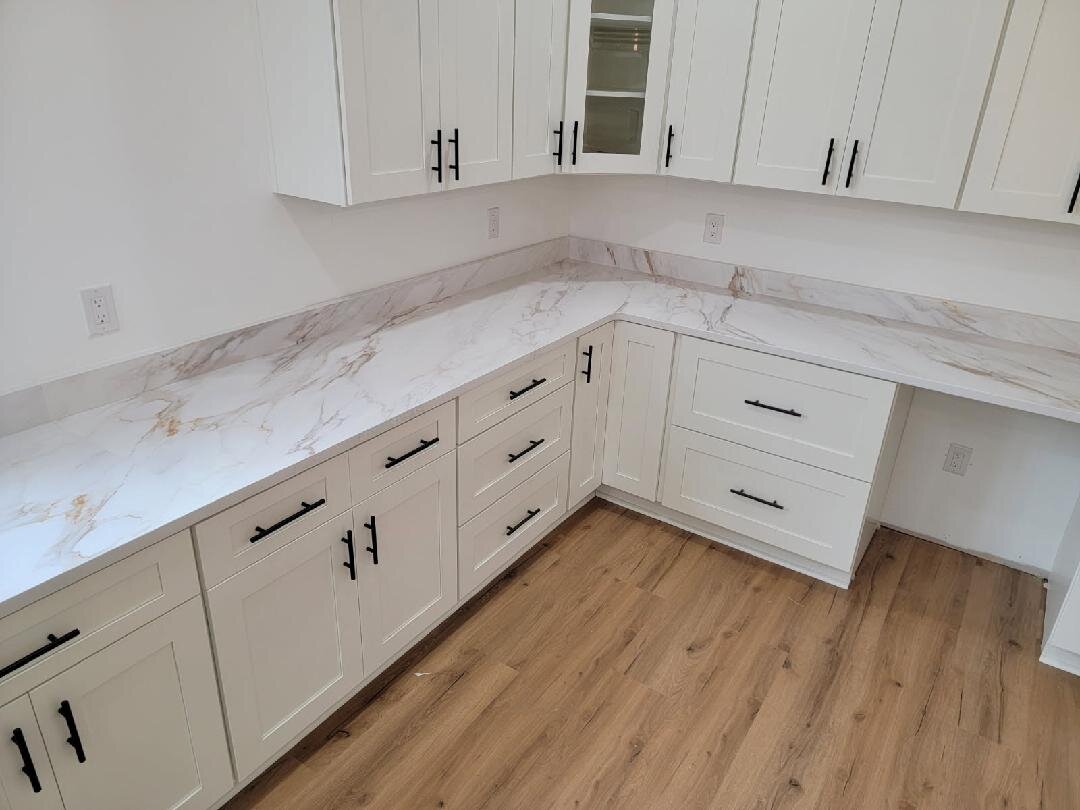 Bright white kitchen with marble-look countertops and black hardware