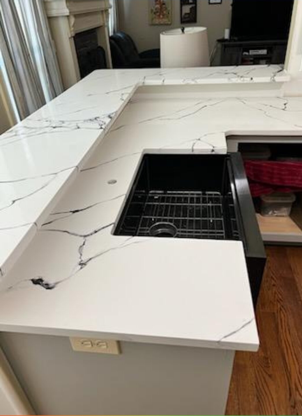 White quartz counter with bold black veining around a black sink