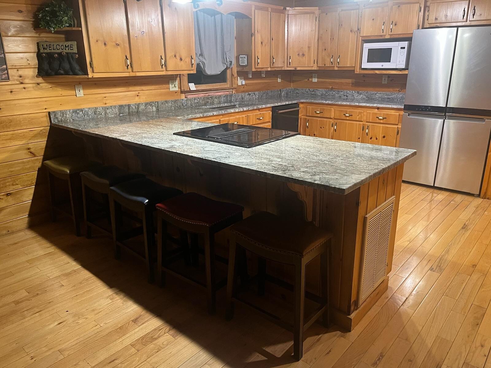 Cabin kitchen with a long gray granite peninsula and bar seating