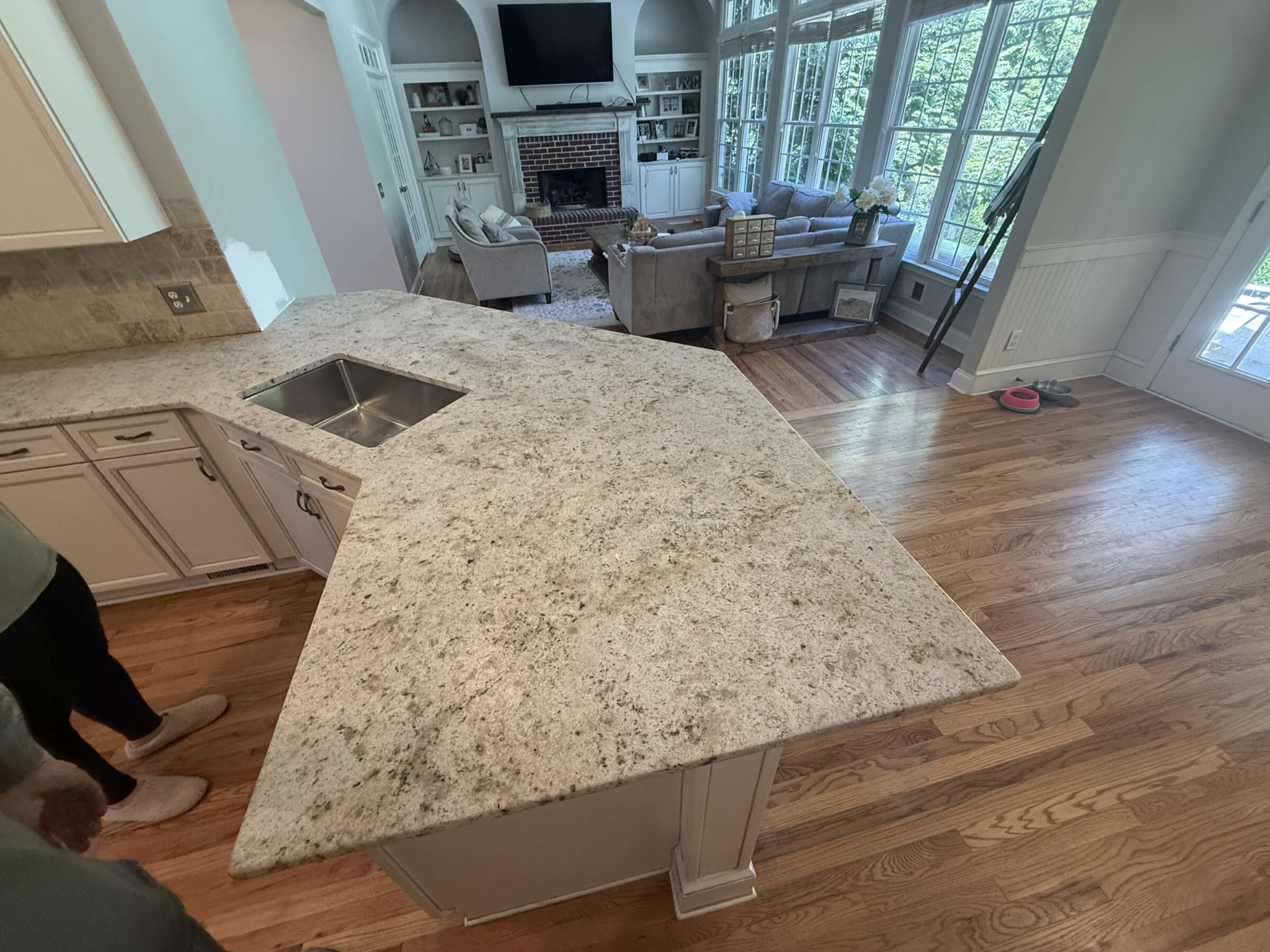 Angled granite peninsula with undermount sink opening to a family room