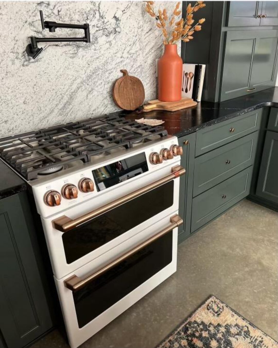 Granite countertops and backsplash surrounding a kitchen range