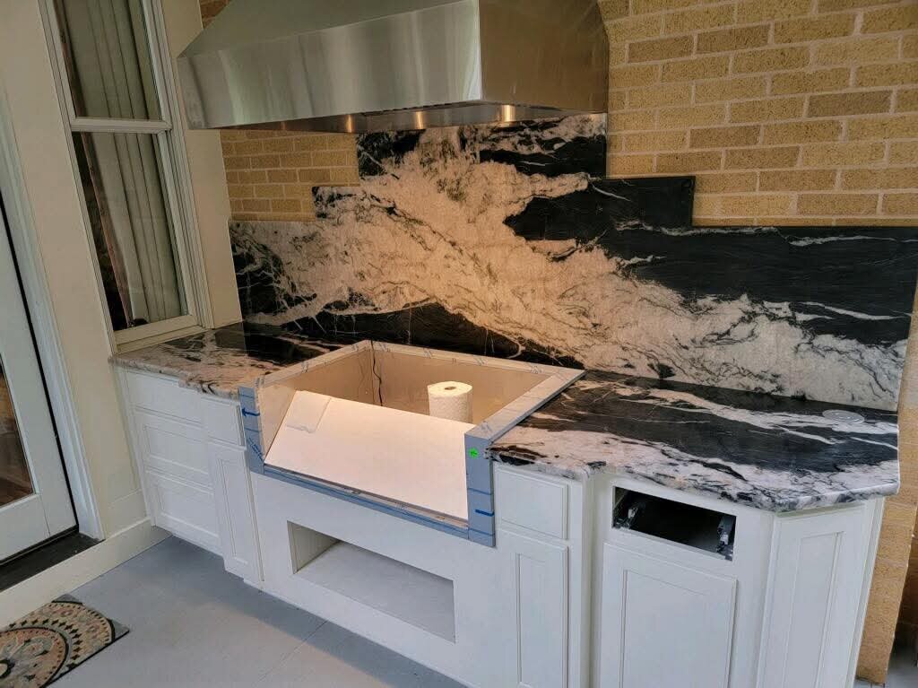 Dramatic black and white stone counters and full backsplash