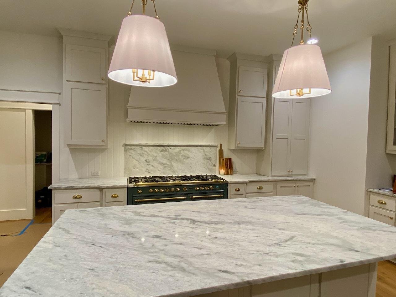 Large white marble island with a matching range backsplash