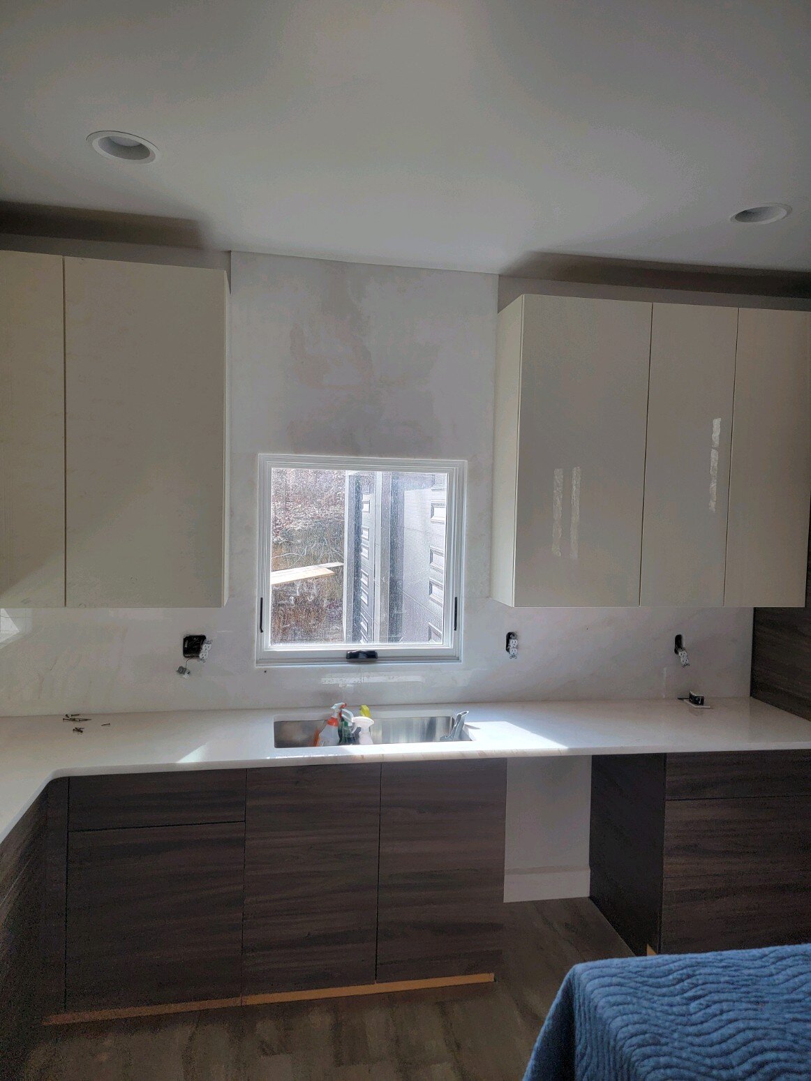 White quartz counters and full-height backsplash with dark wood cabinets