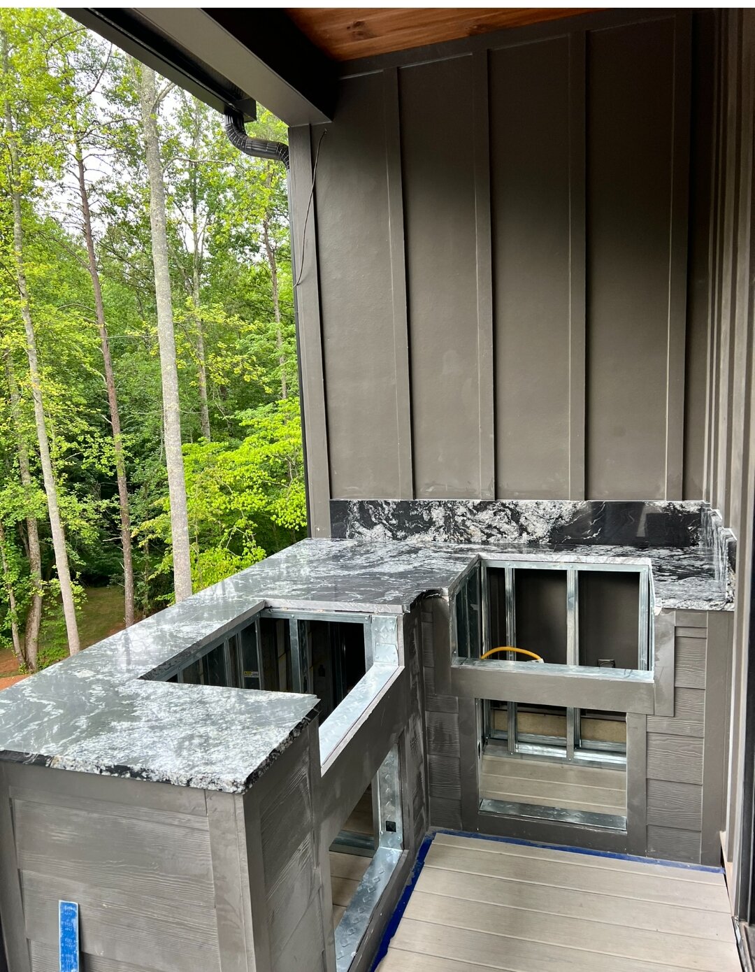 Dark granite countertops installed on an outdoor kitchen frame