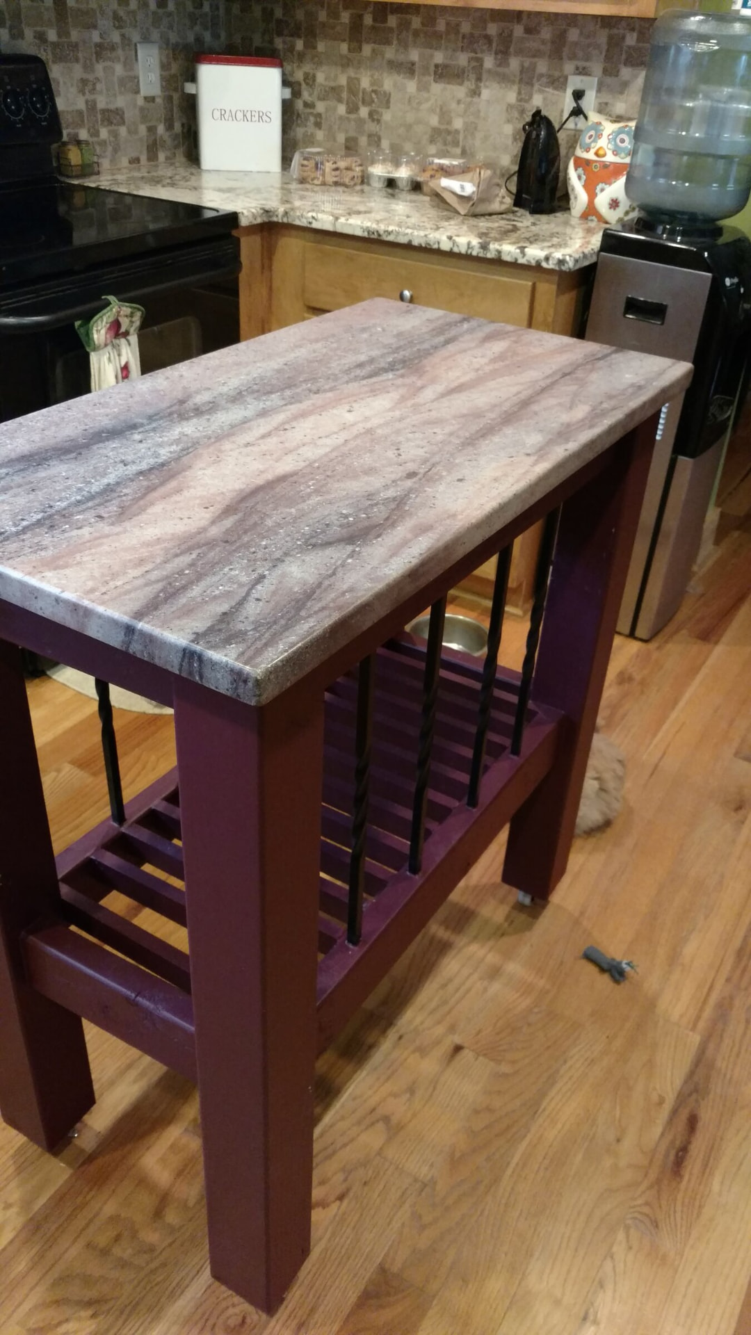 Custom kitchen cart with a veined stone top on an iron-spindle base