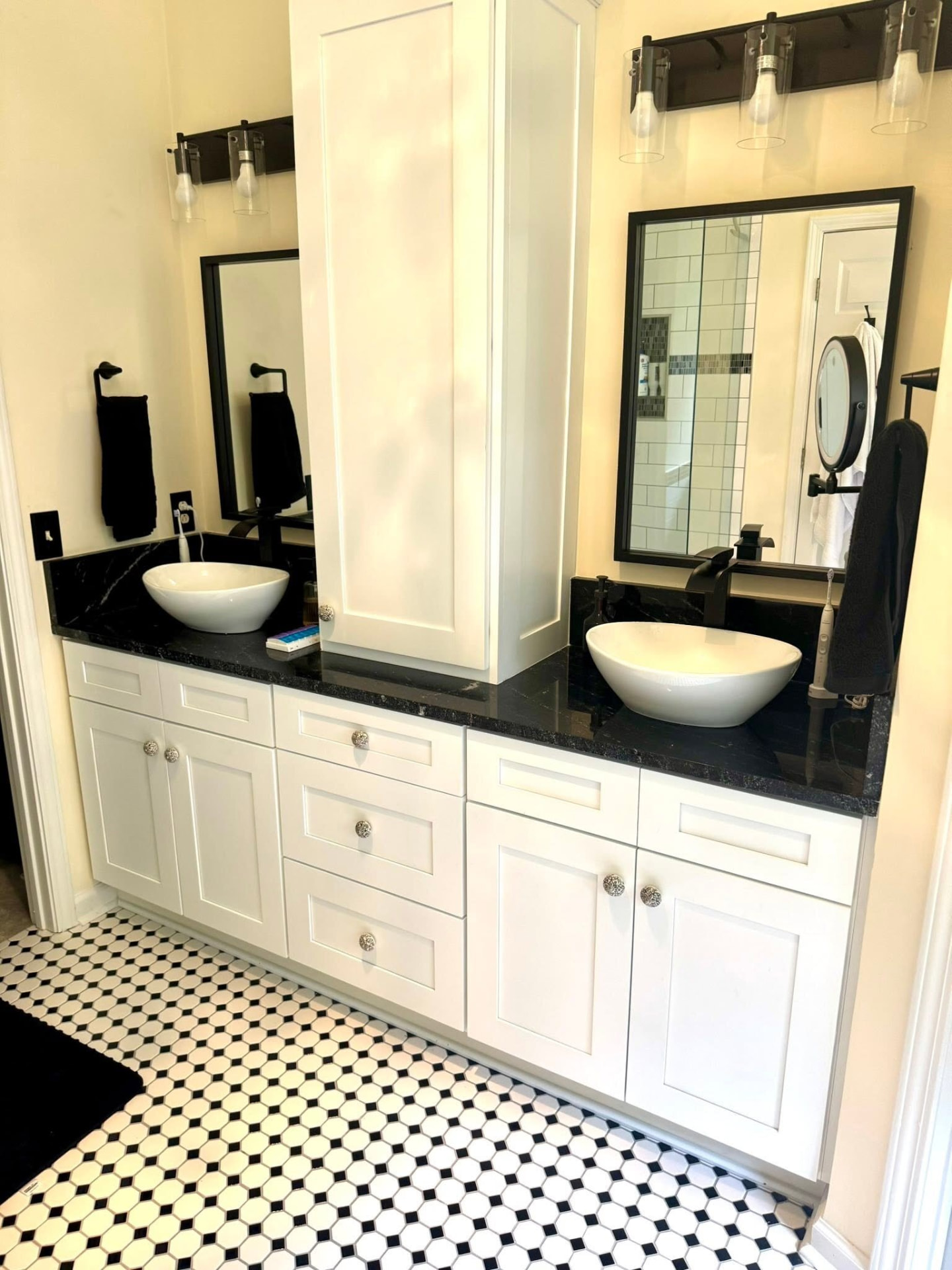 Double bathroom vanity with black stone countertop and vessel sinks