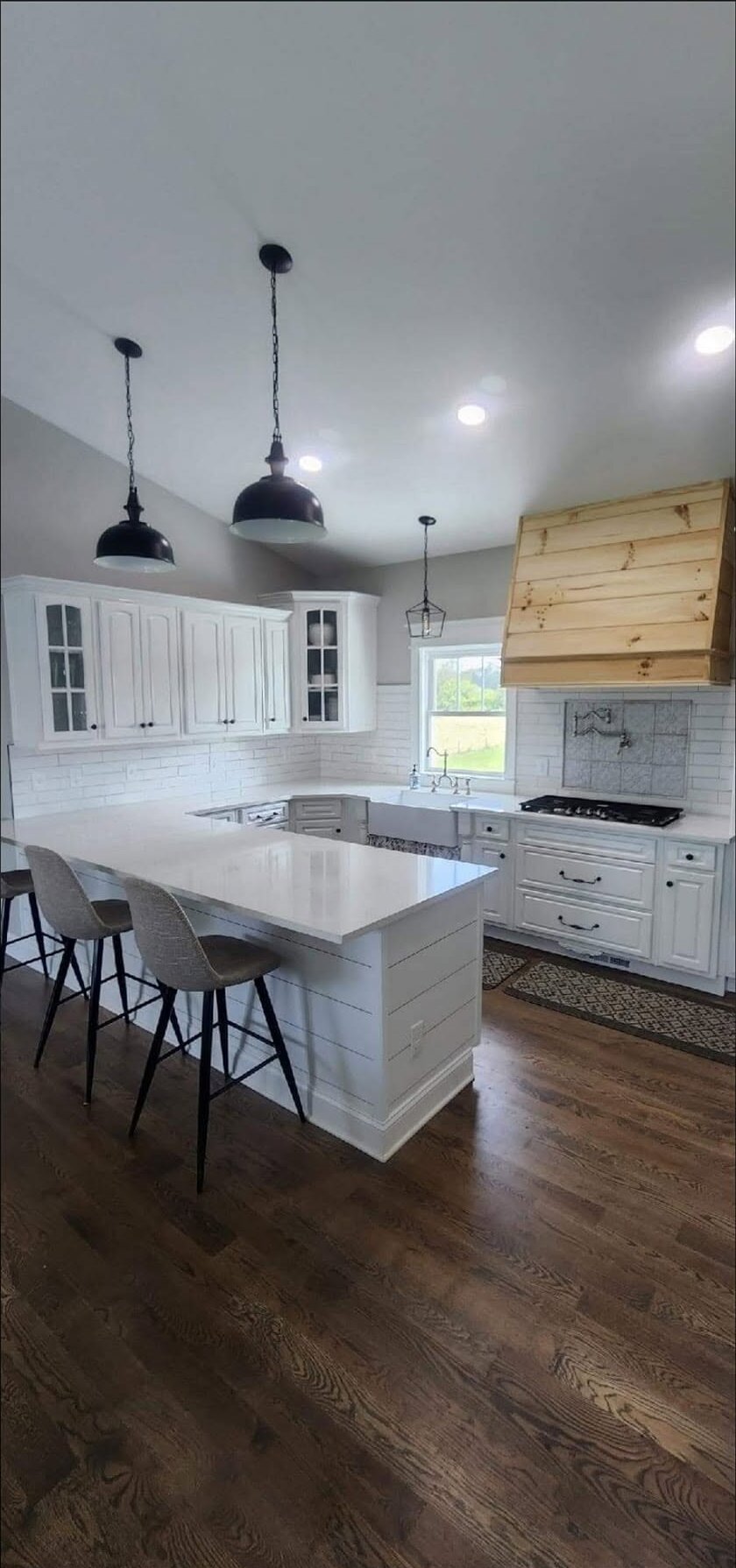 White quartz peninsula in a farmhouse kitchen