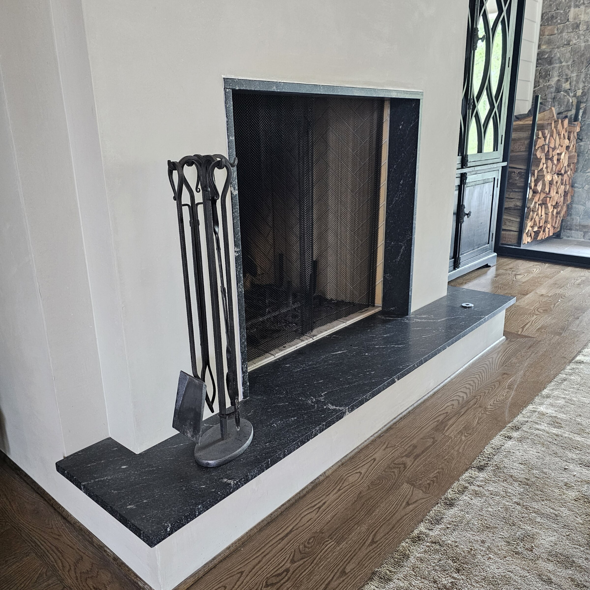 Custom black marble fireplace hearth and surround with white veining