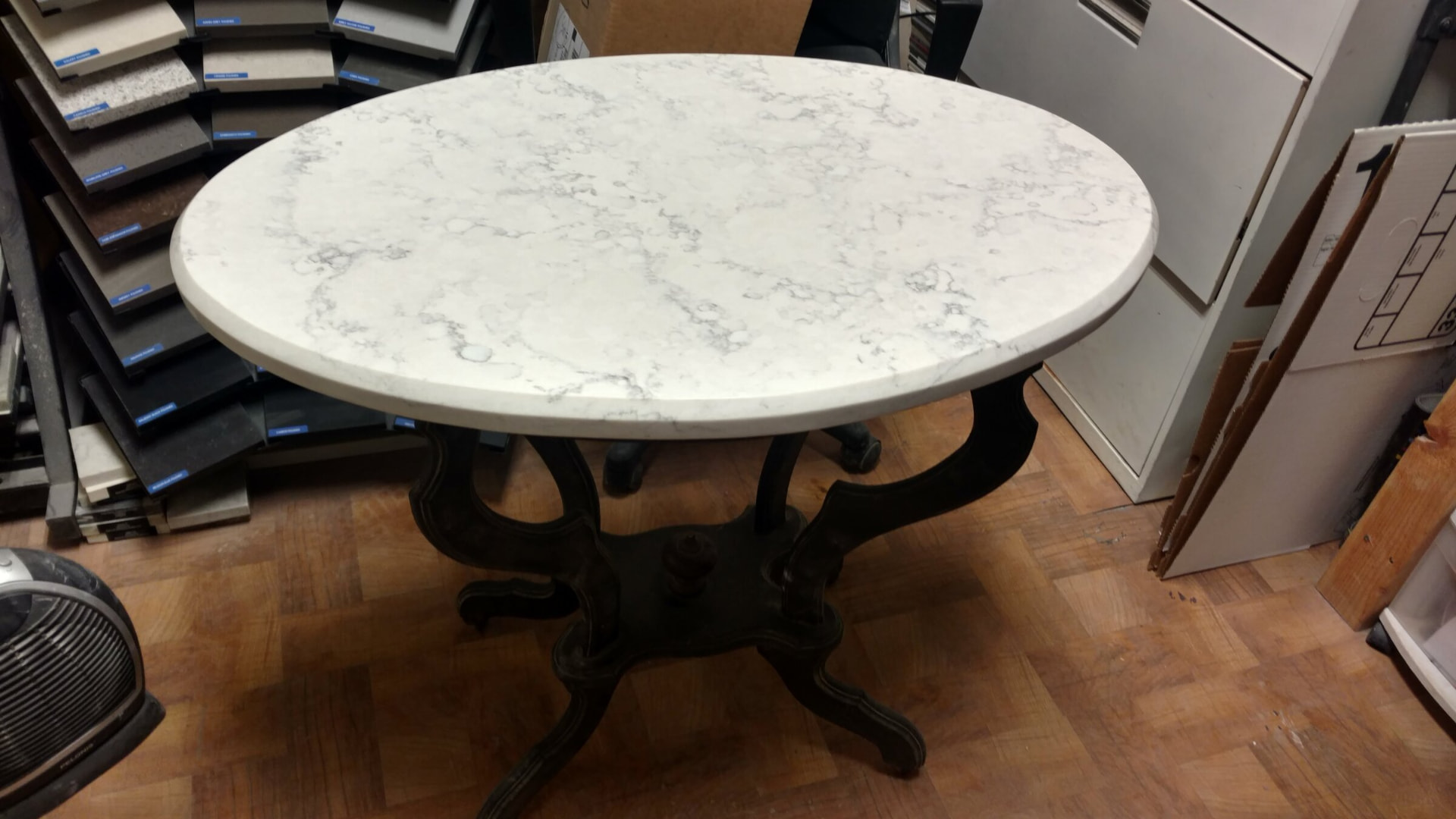 Round white marble table with gray veining on an antique pedestal base