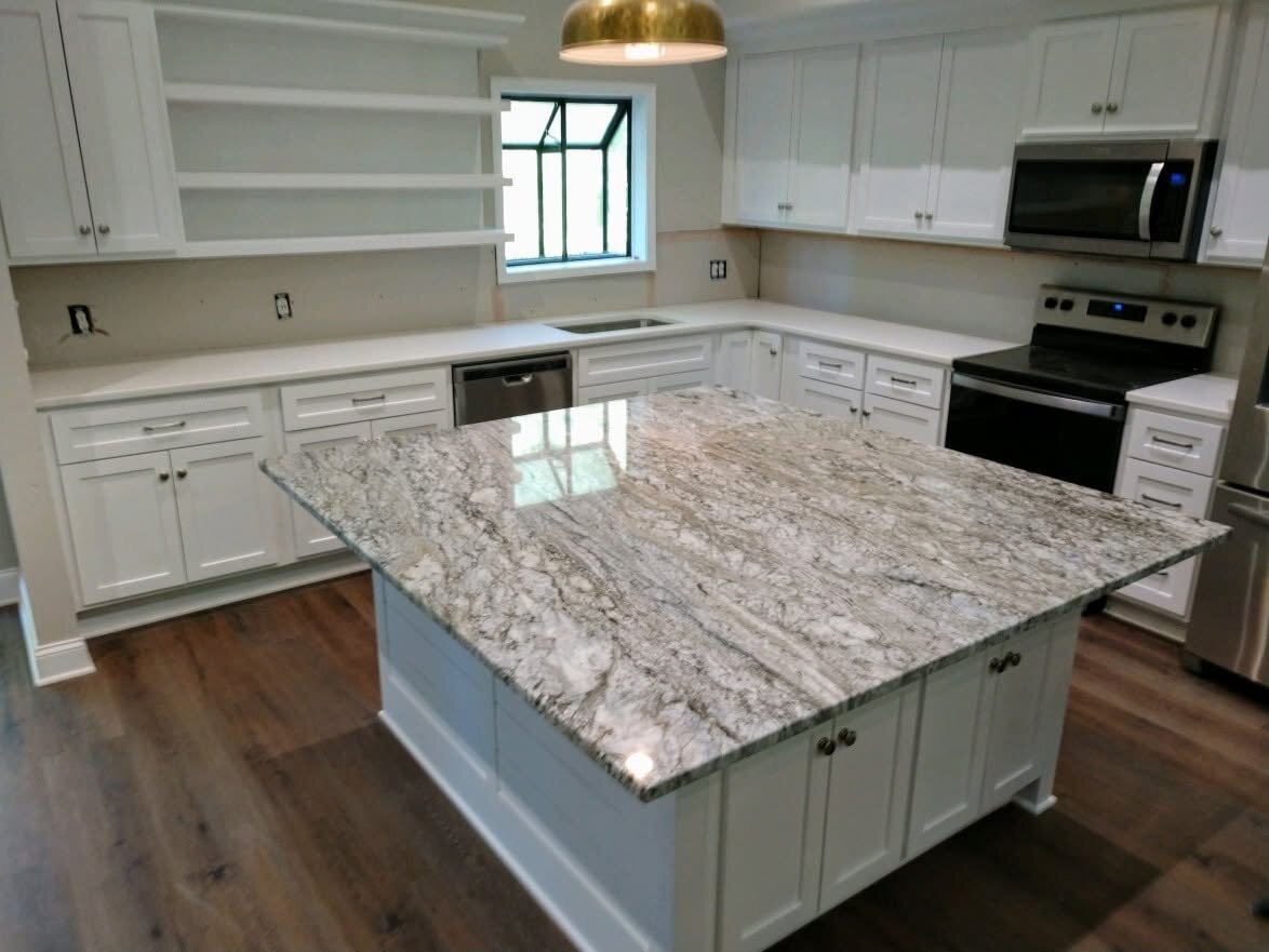 Swirled white granite island in a bright white kitchen