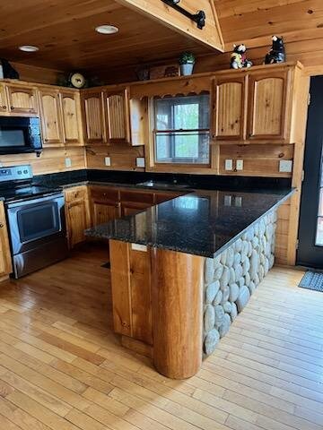 Cabin kitchen with black granite counters and a river-rock peninsula