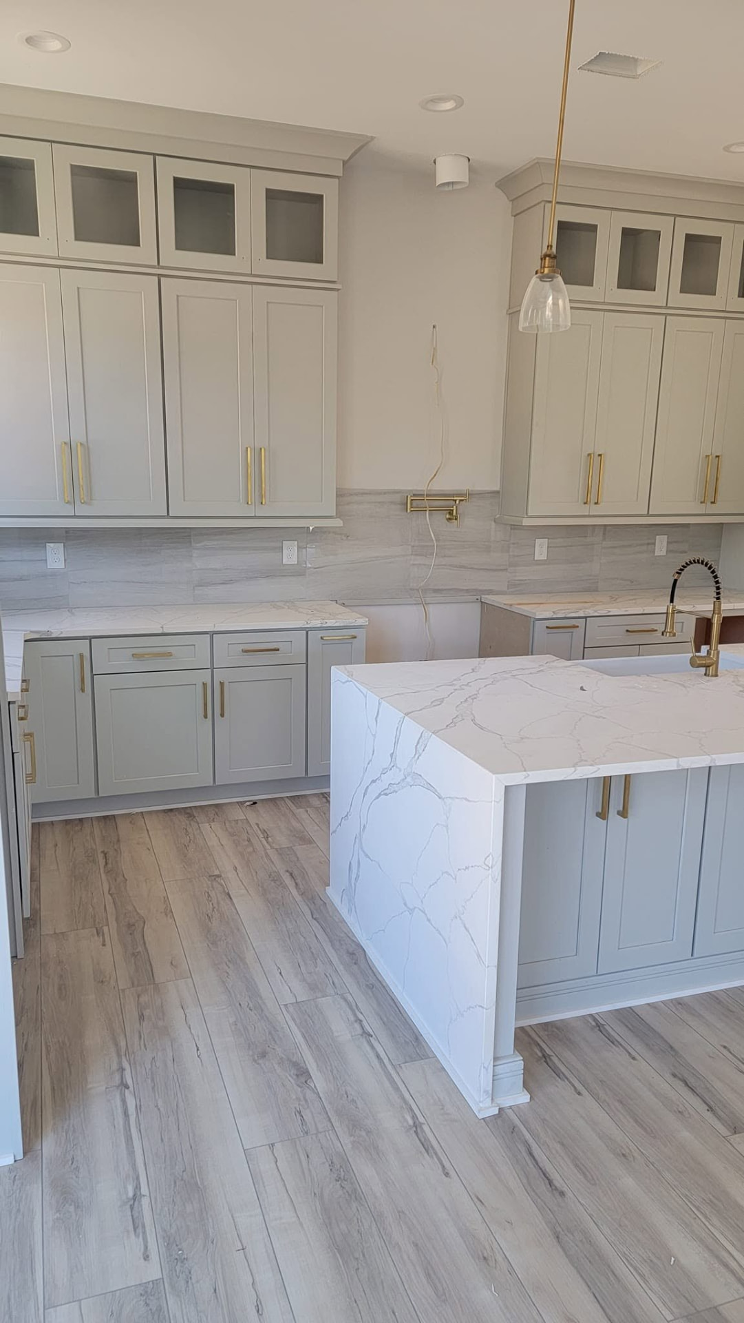 Waterfall quartz kitchen island with brass fixtures